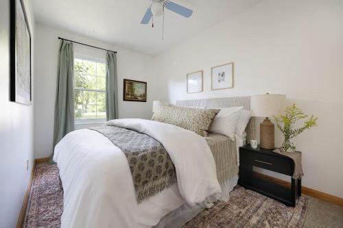een witte slaapkamer met een bed en een raam bij Turntable&Vinyl - Deck - Vibrant - Near IU in Bloomington