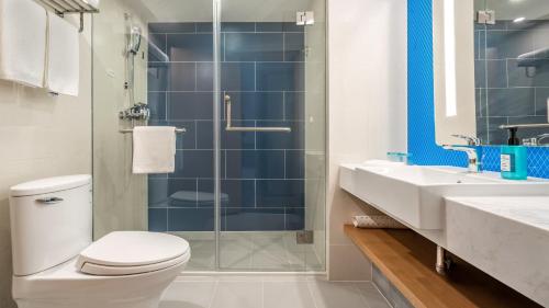 a bathroom with a toilet and a shower and a sink at Holiday Inn Express Qingdao City Center by IHG in Qingdao