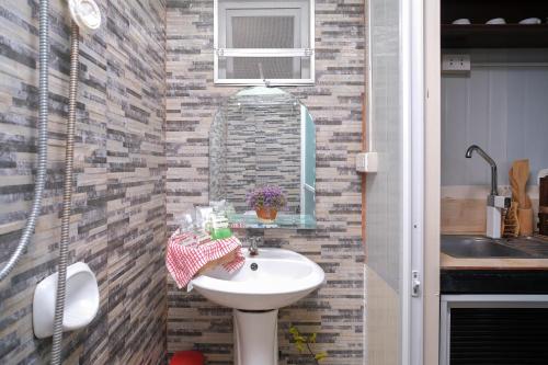 a bathroom with a sink and a brick wall at Golden V Grandeuria Unit E in Malolos