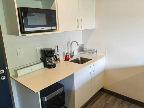 a small kitchen with a sink and a microwave at 804 SECRT Sabana Hermoso Apartamento con Aire Acondicionado in San José