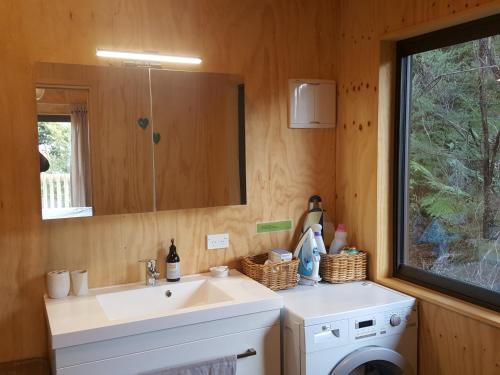 a bathroom with a sink and a washing machine at Yurt retreat in Pangatotara