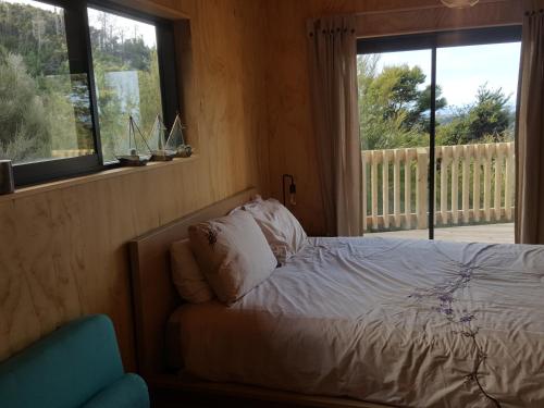 a bedroom with a bed and a window at Yurt retreat in Pangatotara