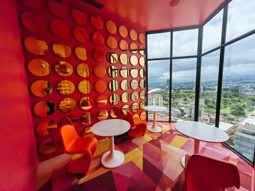 a room with tables and chairs and a large window at 804 SECRT Sabana Hermoso Apartamento con Aire Acondicionado in San José