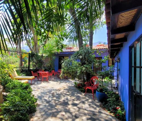 a patio with tables and chairs and palm trees at Estrellita's Bed & Breakfast in Ajijic