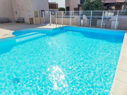 une grande piscine bleue dans un bâtiment dans l'établissement Guest House Yemanja, à Narbonne