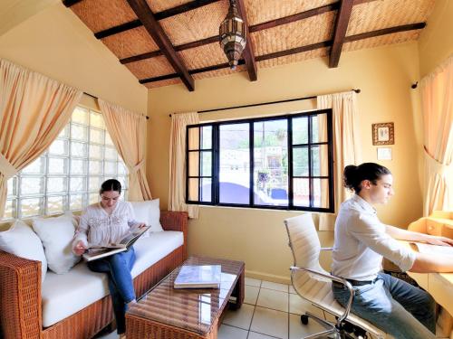 two people sitting on a couch in a living room at Estrellita's Bed & Breakfast in Ajijic
