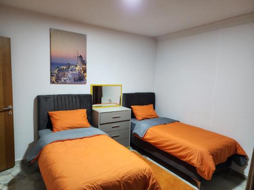 a bedroom with two beds and a dresser and a mirror at Taksim Square Residence, Two bedrooms, pool sauna gym in Istanbul