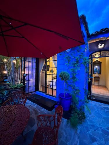 a patio with chairs and a red umbrella at Estrellita's Bed & Breakfast in Ajijic