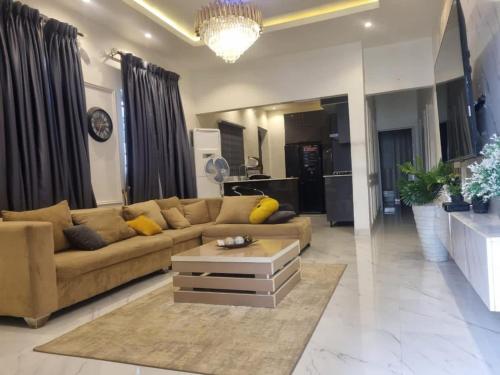 uma sala de estar com um sofá e uma mesa de centro em Shagari Estate Prestige 3-Bedroom Apartments. em Lagos