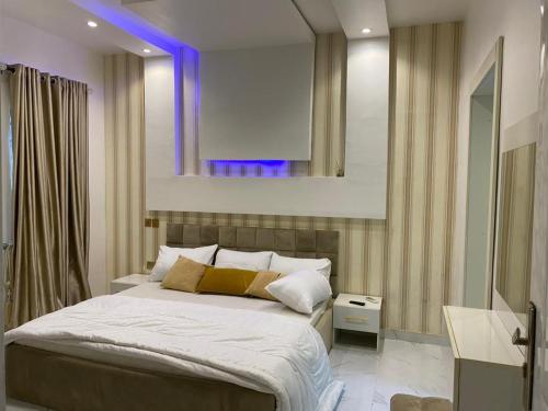 um quarto com uma cama grande e um espelho em Shagari Estate Prestige 3-Bedroom Apartments. em Lagos