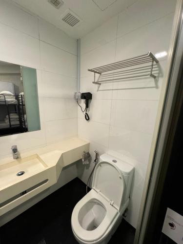 a bathroom with a toilet and a sink and a mirror at D'Nova Hotel Bugis in Singapore