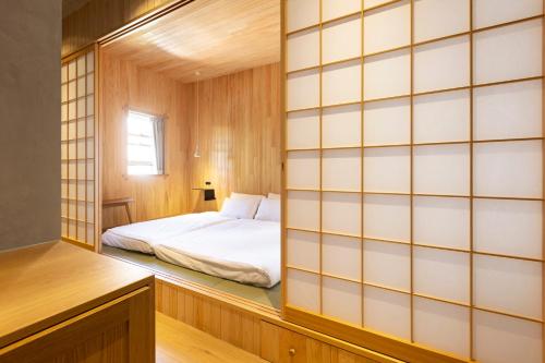 a small bedroom with a bed in a wooden wall at In The Brick Spa And Hotel in Melbourne