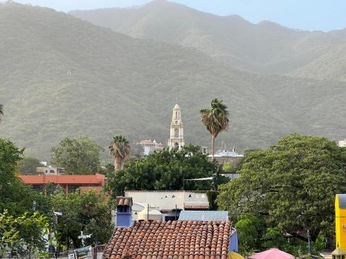 a city with a clock tower and mountains in the background at Estrellita's Bed & Breakfast in Ajijic
