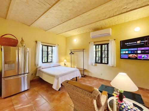 a bedroom with a bed and a refrigerator and a table at Estrellita's Bed & Breakfast in Ajijic