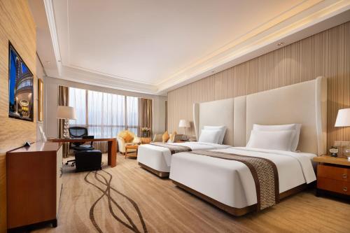 a hotel room with two beds and a desk at Shenzhen Baolilai International Hotel (Baoan, Fuyong) in Bao'an