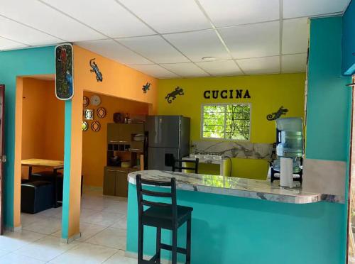 a kitchen with a black chair at a counter at Casa de Emilia in Santa Ana
