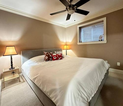 ノースバンクーバーにあるSerene 2BR Suite at Lloyd Aveのベッドルーム1室(大型ベッド1台、シーリングファン付)
