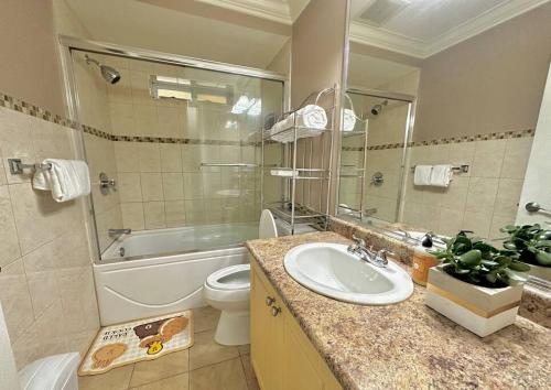 ノースバンクーバーにあるSerene 2BR Suite at Lloyd Aveのバスルーム(洗面台、トイレ、バスタブ付)