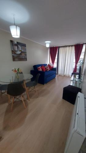 a living room with a blue couch and a table at Departamentos 2 dormitorios incluye estacionamiento. centro Santiago in Santiago