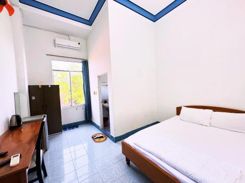 - une chambre avec un lit, un bureau et une fenêtre dans l'établissement Moonlight Hotel, à Nha Trang
