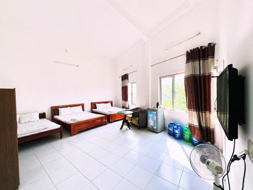 um quarto com 2 camas e uma televisão de ecrã plano em Moonlight Hotel em Nha Trang