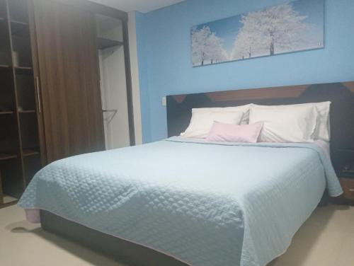 a bedroom with a large white bed with pink pillows at Apartamentos Turísticos en Laureles- Estadio, Medellin in Medellín