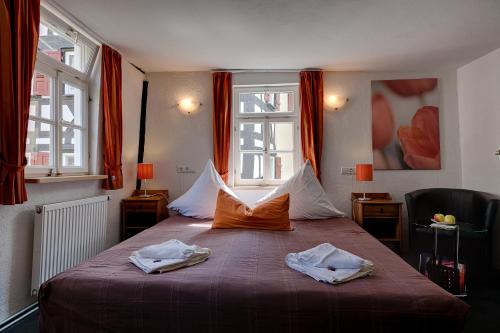 a bedroom with a bed with two towels on it at Hotel Kleine Radlerherberge in Möckmühl