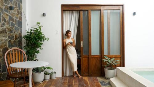 a woman standing in front of a door at Lugadia Villas in El Nido