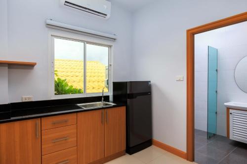 een keuken met een zwarte koelkast en een raam bij Pattaya Private Villa - Pool,Sauna,Snooker,BBQ in Pattaya South