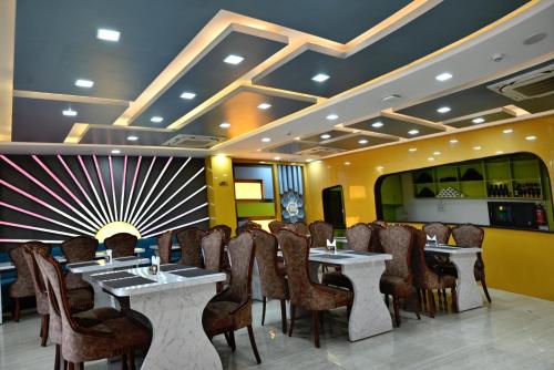 a restaurant with tables and chairs in a room at Hotel Navraj Palace in Gomti Nagar