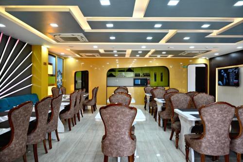 a dining room with tables and chairs in a room at Hotel Navraj Palace in Gomti Nagar
