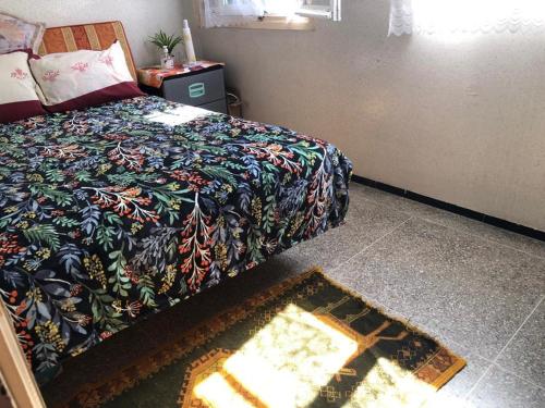 1 dormitorio con cama y alfombra en el suelo en BATRISS'S HOUSE, en Casablanca