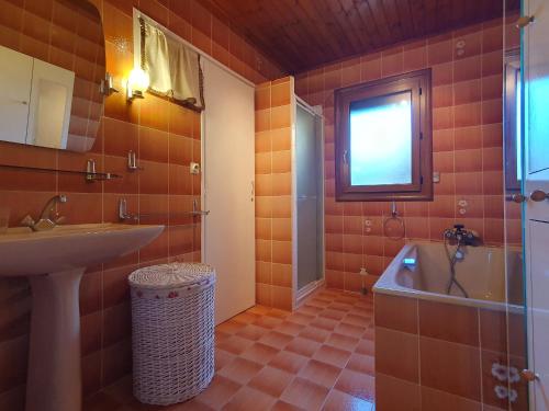 une salle de bain avec un lavabo et une baignoire dans l'établissement Maison confortable avec jardin proche plage, 3 chambres, WiFi, animaux sur demande - FR-1-476-135, à LʼAiguillon-sur-Mer