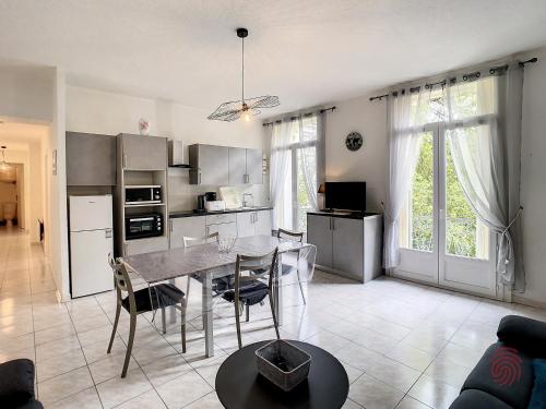 une cuisine et une salle à manger avec une table et des chaises dans l'établissement Charmant F3 avec Wi-Fi, animaux acceptés, proche thermes - Lamalou-les-Bains - FR-1-451-148, à Lamalou-les-Bains