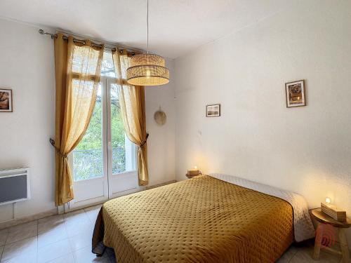 une chambre avec un lit et une grande fenêtre dans l'établissement Charmant F3 avec Wi-Fi, animaux acceptés, proche thermes - Lamalou-les-Bains - FR-1-451-148, à Lamalou-les-Bains
