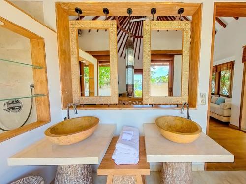 Eliana Resort And Spa في نيمبرالا: مغسلتين في حمام مع مرآيتين
