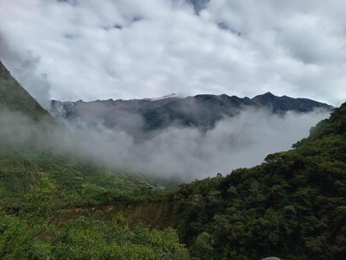 クスコにあるRUMI WASI HOSTELの山を背景に霧の谷
