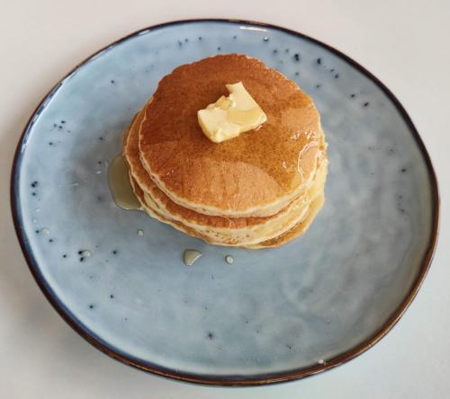 a stack of pancakes with butter on a blue plate at Kahoy Cottages in Siquijor