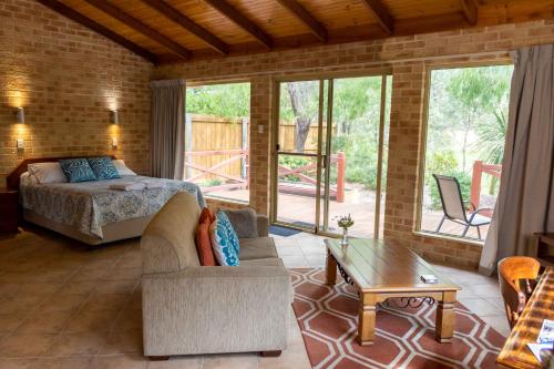 a bedroom with a bed and a couch and a table at Spring Bay Villas, Denmark, WA in Denmark
