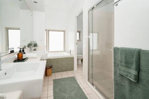 a white bathroom with a sink and a shower at Luxurious Beachside Living in Mudjimba