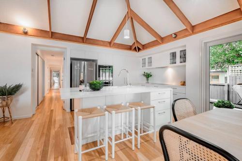 a kitchen with a white island and a table at Luxurious Beachside Living in Mudjimba