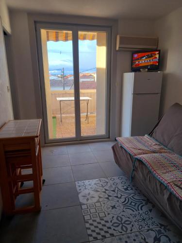 une chambre avec un lit, une table et une fenêtre dans l'établissement Studio avec grande terrasse 2 personnes à Valras plage, à Valras-Plage