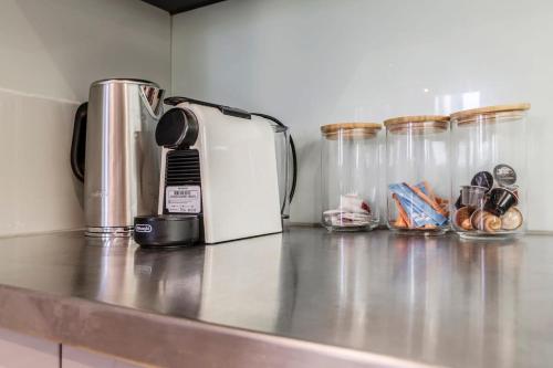 a counter top with a coffee maker and some glass jars at 2-Bedroom Apartment in Melbourne City with carpark in Melbourne