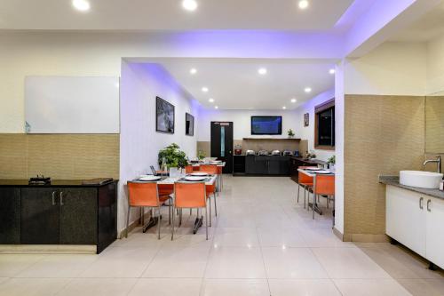 eine Küche und ein Esszimmer mit einem Tisch und Stühlen in der Unterkunft Nevesa Inn in Bangalore