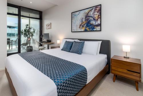 a bedroom with a king sized bed and a desk at Spacious 1-Bed with View in Central Location in Canberra