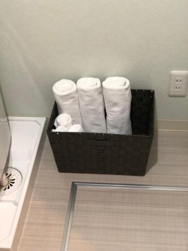 a basket filled with white towels in a bathroom at Apartment Heights HANA in Sakai