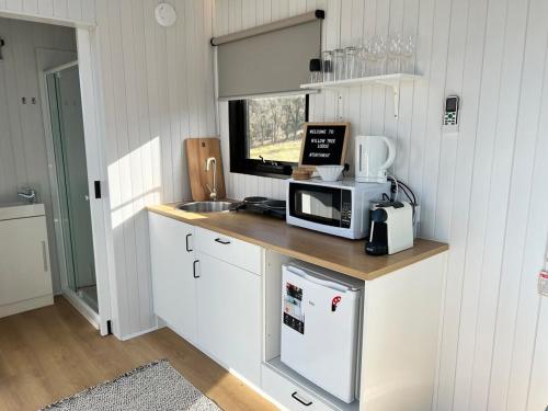 a kitchen with a counter with a microwave and a sink at Willow Three Tiny House in Willow Tree