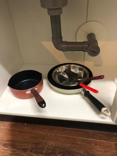 a stove top with a pan and utensils on it at Apartment Heights HANA in Sakai