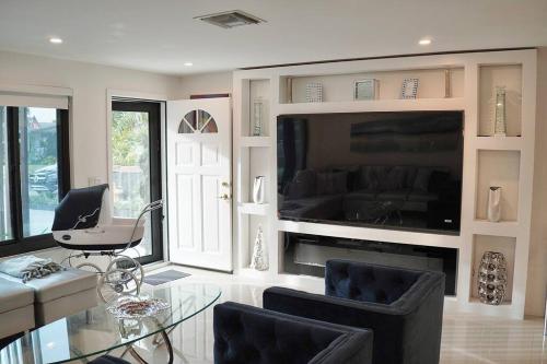a living room with a glass table and a tv at Stylish home in Dania Beach