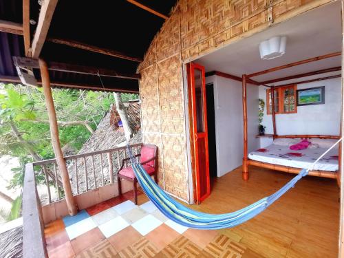 a room with a hammock in a house at Sea Esta Beach House in Boljoon